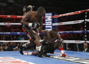 Terence Crawford (L) drops Dierry Jean Saturday in their WBO super lightweight title fight in Omaha, Neb. (Mikey Williams/Top Rank)